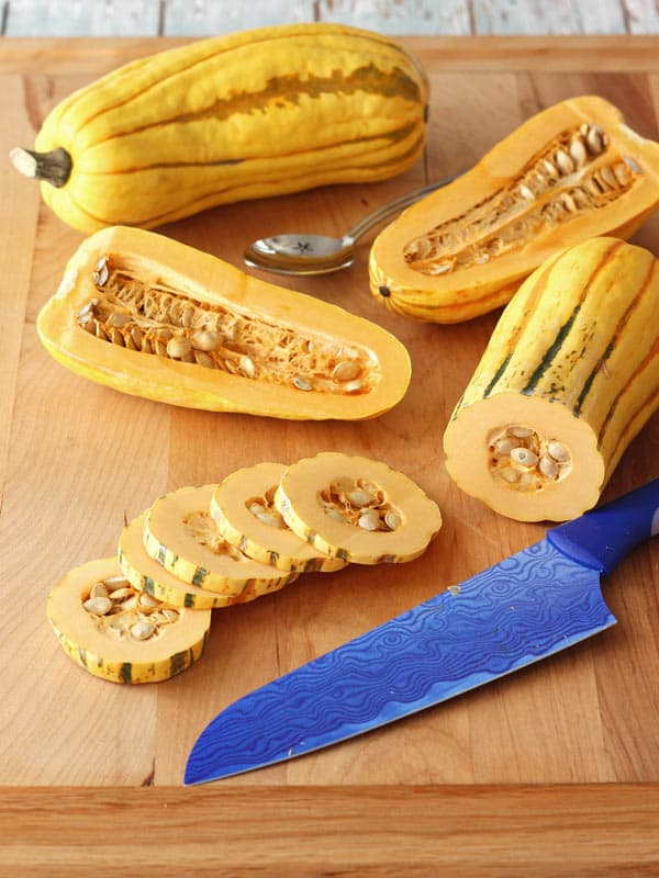 Sliced delicata squash on a cutting board.