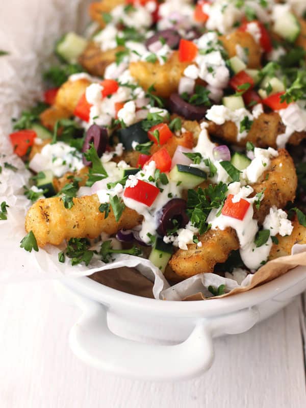 Loaded fries in a white dish.