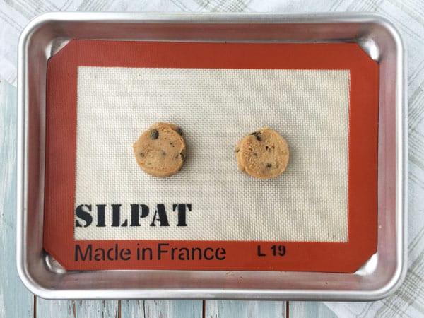 Raw cookie dough on a silicone mat lined toaster oven cookie sheet.