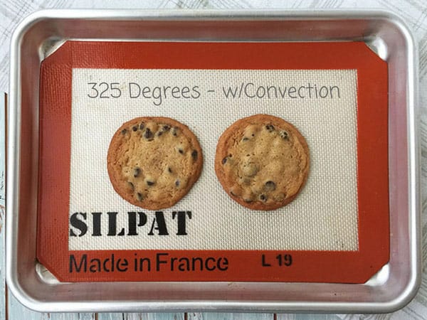 Warm and gooey chocolate chip cookies on a sheet pan.