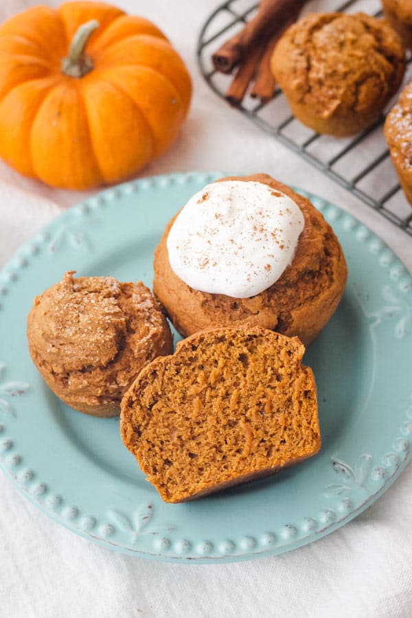 Plate with cinnamon sugar and whipped cream topped muffins.