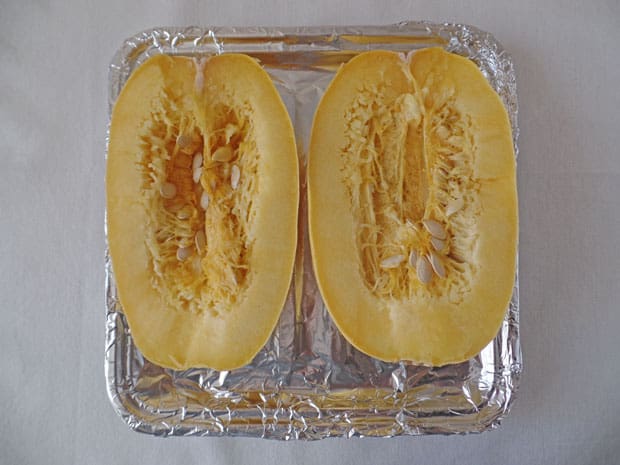 Spaghetti squash halves on a baking sheet.