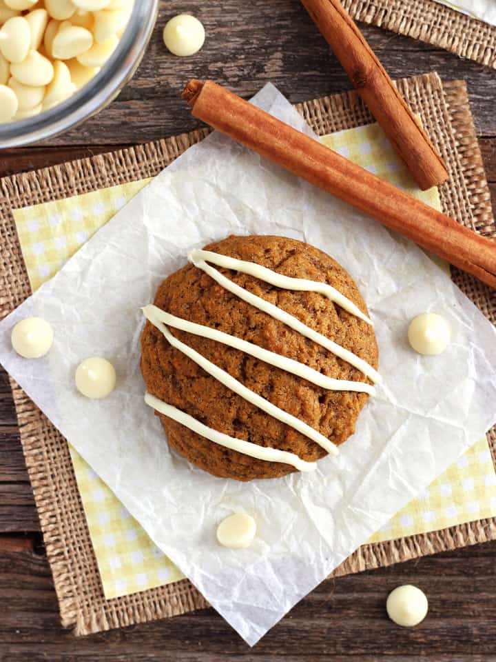 Cookie on a piece of parchment paper with cinnamon sticks.