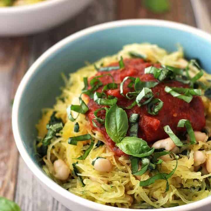 Blue bowl with roasted squash, beans, and tomato sauce.