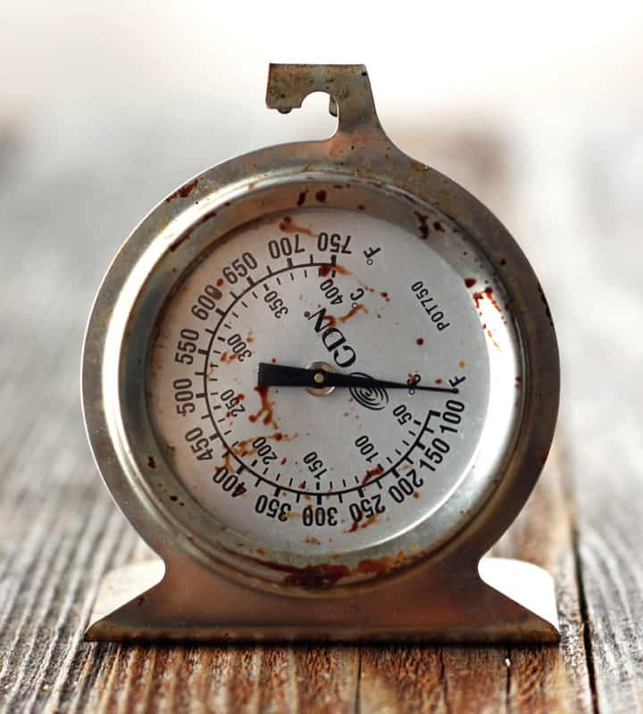 Oven thermometer on a wooden table.