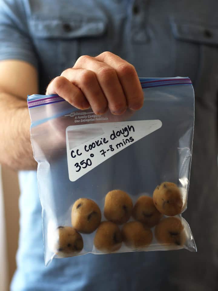 Man holding a bag of frozen balls of cookie dough.