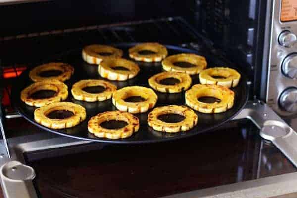 Roasted slices of delicata squash on a pizza pan in a toaster oven