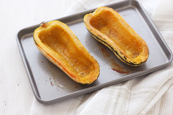 Cooked delicata squash boats on a toaster oven baking sheet.
