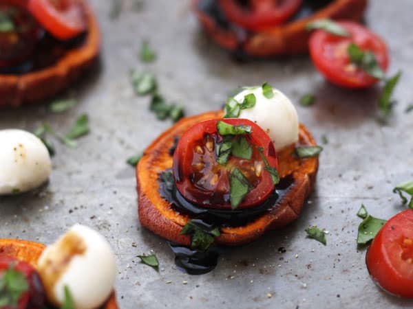 Sweet potato slices topped with tomatoes and mini mozzarella balls.