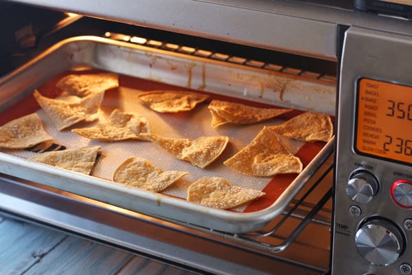 Corn tortilla chips baking in a toaster oven.