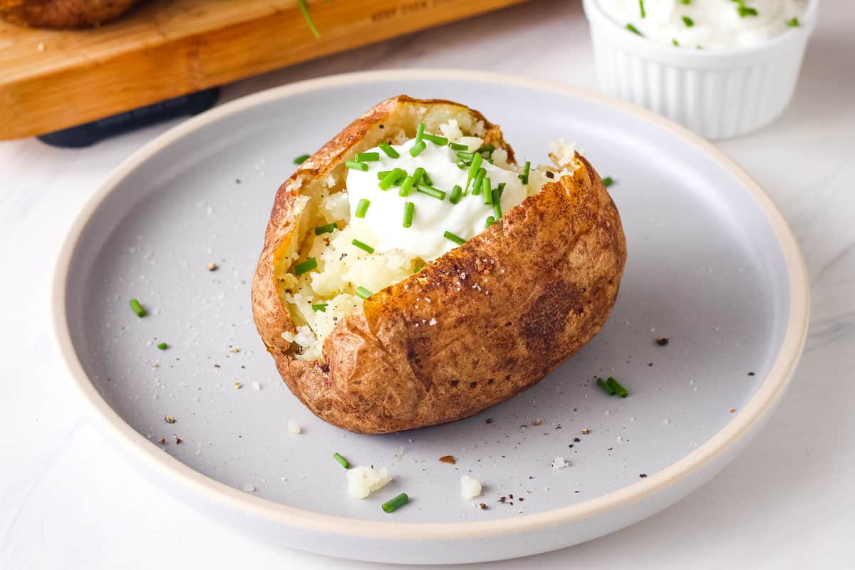 Baked potato topped with Greek yogurt and fresh chives.