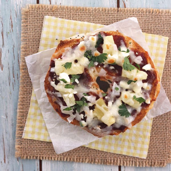 Toasted onion bagel with BBQ sauce, feta cheese, mozzarella cheese, onions and cilantro.