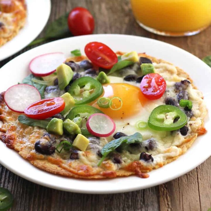 Closeup of breakfast tostada topped with jalapeño slices and avocado.