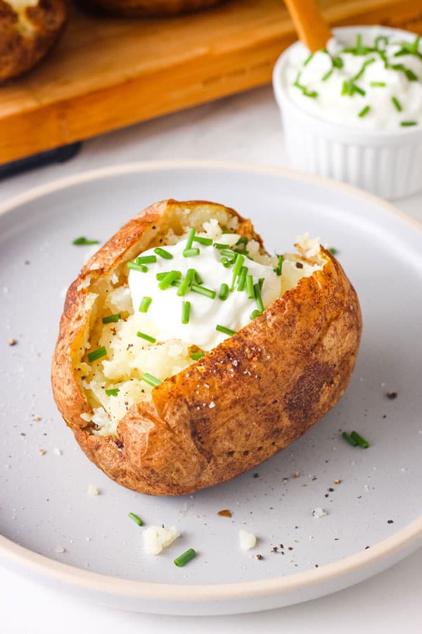 Closeup up of a fluffy baked potato on a blue plate.
