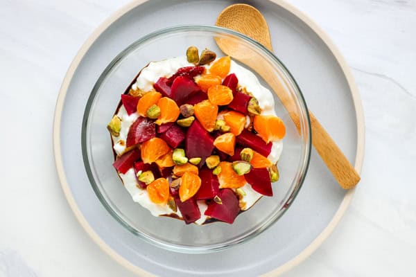 Bowl of cottage cheese with diced beets, mandarin orange, and pistachio.