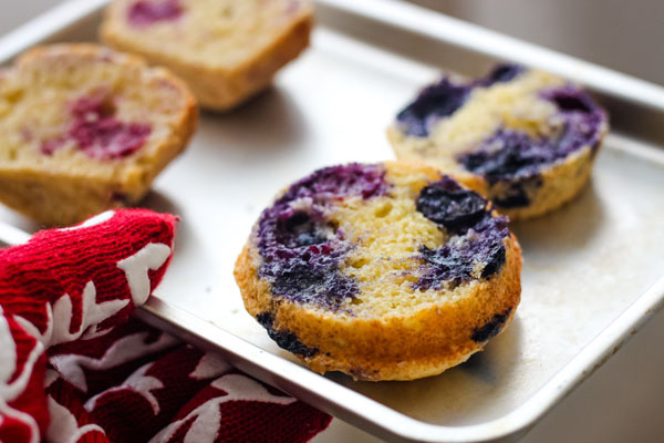 Buttery toasted blueberry muffin halves on a baking sheet.