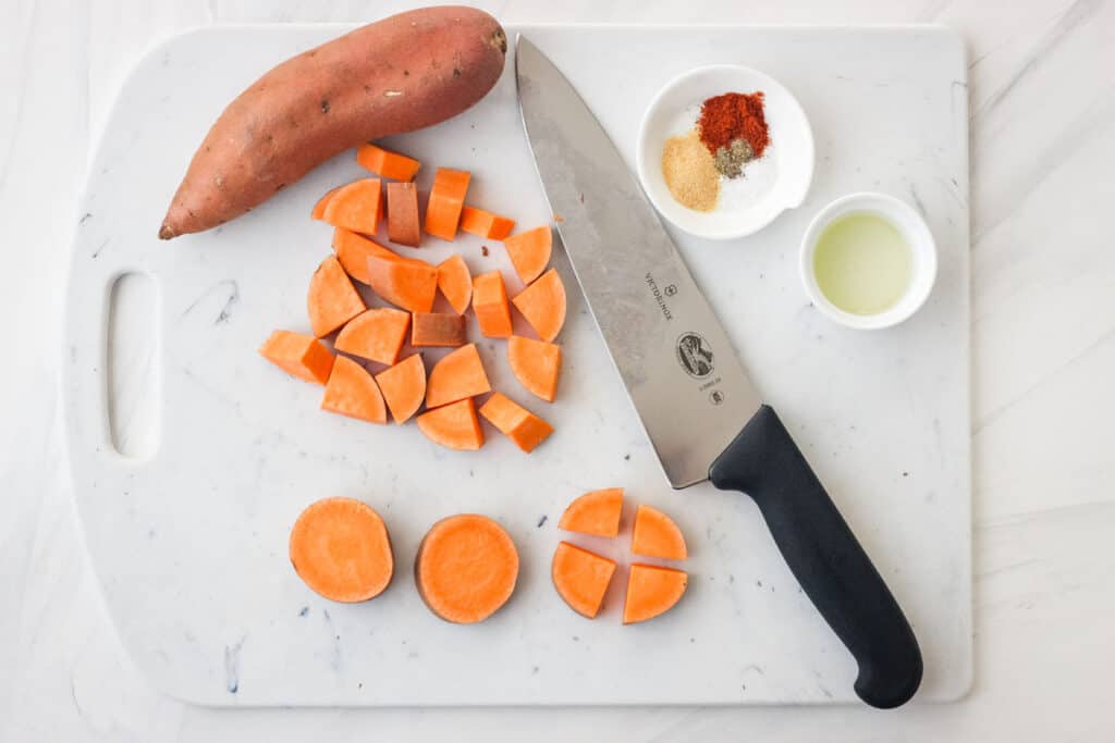 Sweet potatoes chopped on a cutting board.