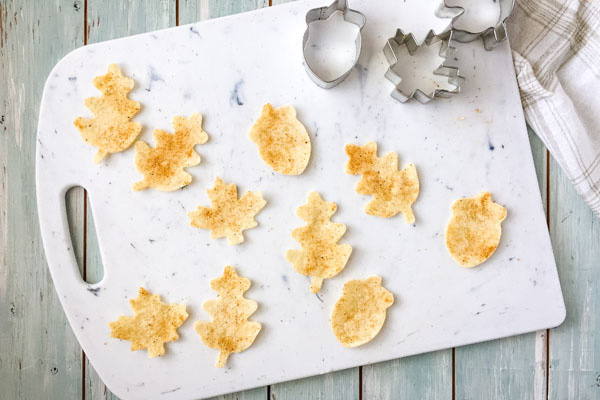 Leaves and acorn tortilla pieces on a cutting board.