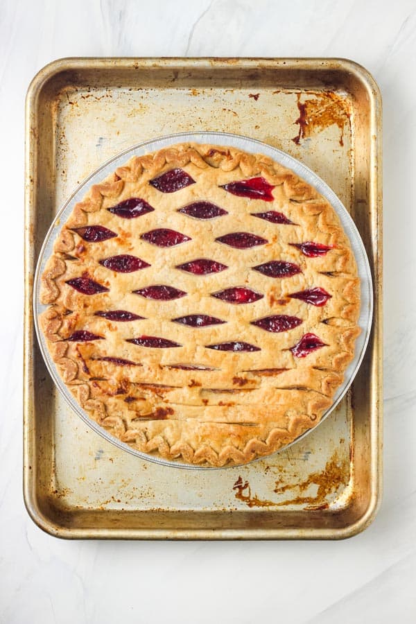 Overhead view of baked pie cooling on a sheet pan.