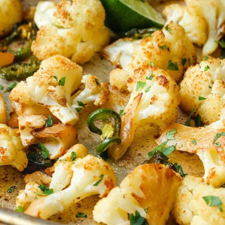 Golden roasted cauliflower florets on a sheet pan.