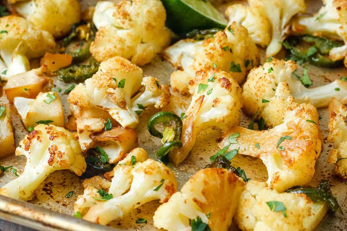 Golden roasted cauliflower florets on a sheet pan.