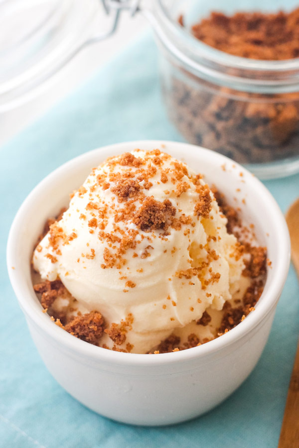 Ramekin of vanilla ice cream topped with graham cracker crumble.