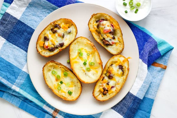 Overhead view of filled potato skins on a plate.