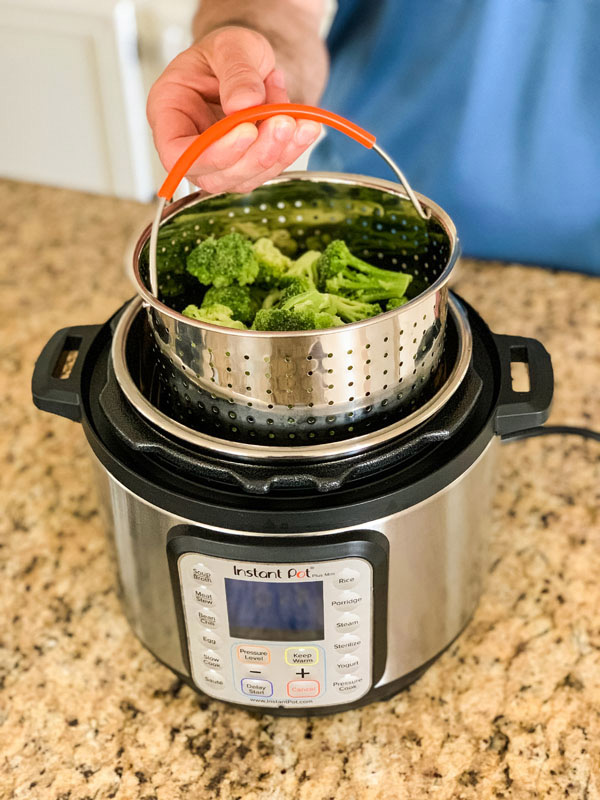 Frozen broccoli in a steamer basket inside a 3 Quart Instant Pot.