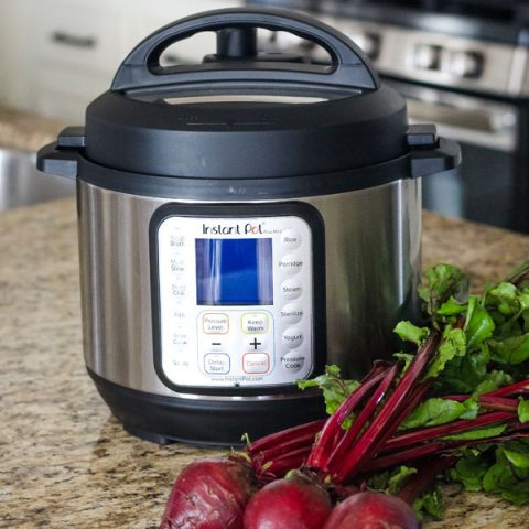 Instant Pot Mini Duo Plus on a kitchen counter with a bunch of beets.