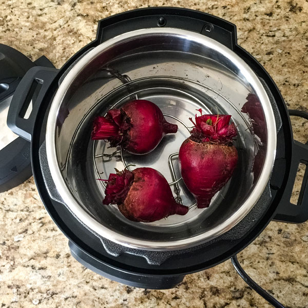 Beets on a metal rack inside of a 3 quart instant pot mini.