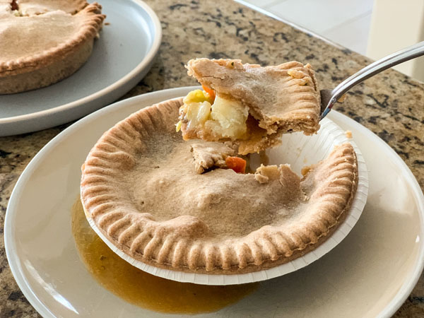 Scooped forkful of a pot pie over a tan plate.