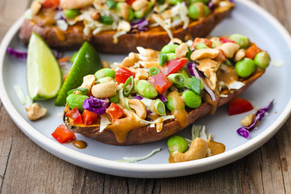 A blue plate with sweet potato halves and lime wedges.