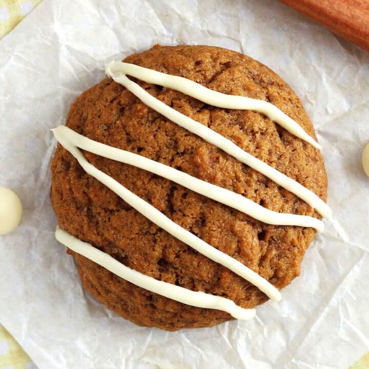 Closeup of soft pumpkin cookie drizzled with melted white chocolate chips.