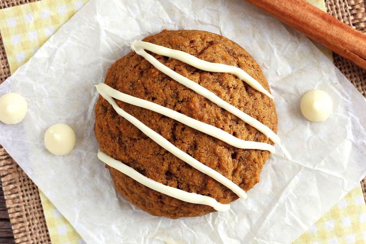 Closeup of soft pumpkin cookie drizzled with melted white chocolate chips.