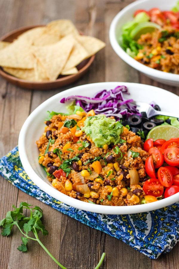 A white bowl with spicy quinoa on a wooden table.