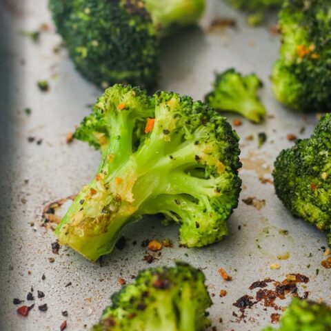 Cooked broccoli on a metal sheet pan.