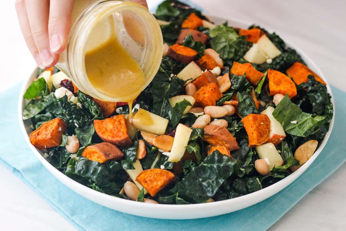 Dijon dressing poured onto a salad.