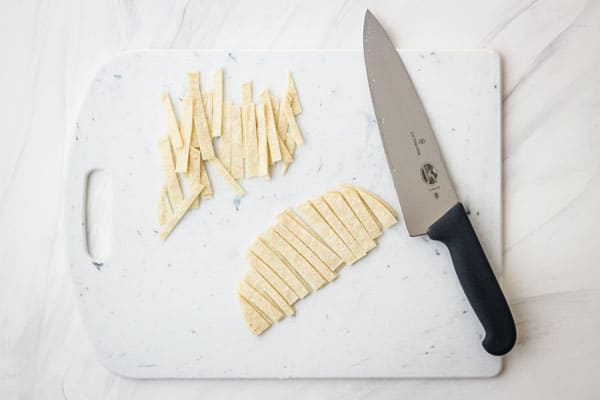 Cutting board with sliced tortillas.