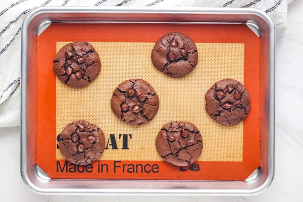 Small batch of double chocolate cookies cooling on a sheet pan.