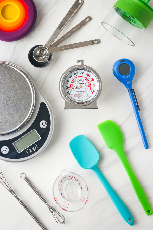 Digital scale, oven thermometer, mini rubber spatula, and more small kitchen tools.