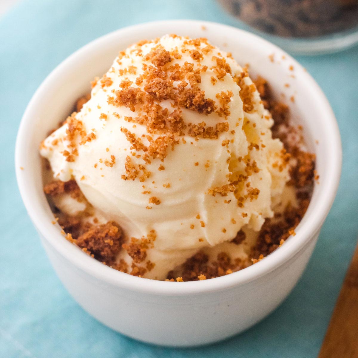 Close up of vanilla ice cream topped with graham cracker crumble.