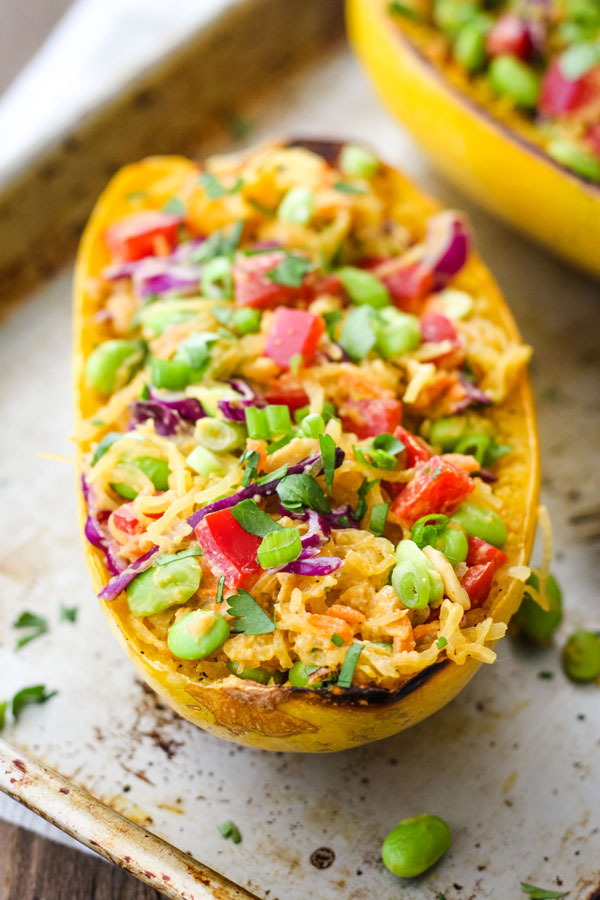 A stuffed spaghetti squash bowl on a metal baking sheet.