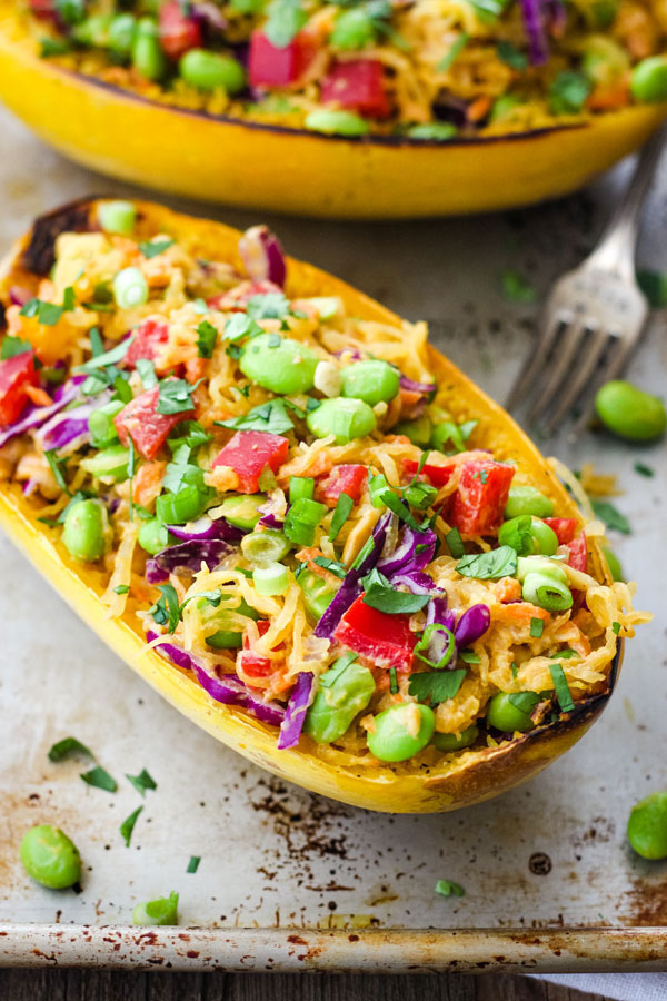 Baked spaghetti squash half loaded with vegetables and edamame.