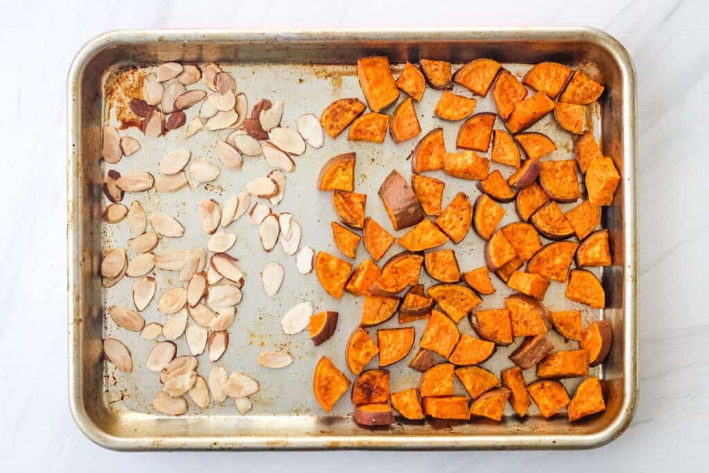 Toasted almond slices and sweet potatoes on sheet pan.