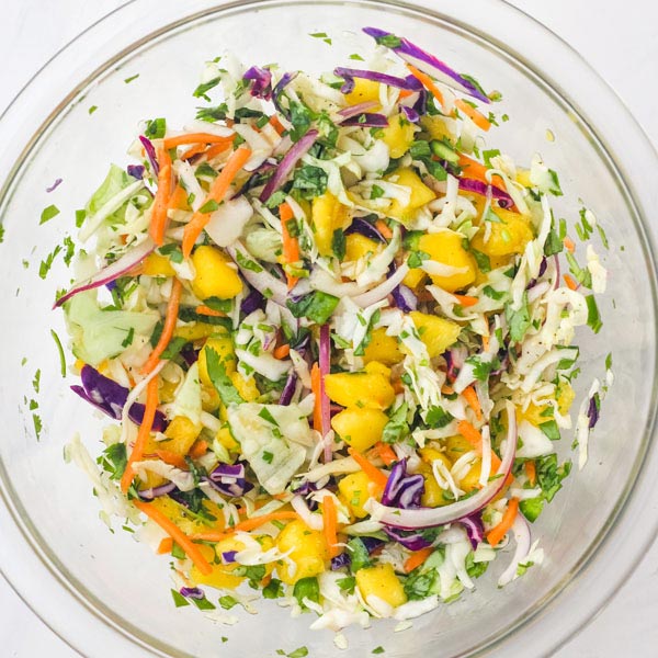 Mango slaw in a glass bowl.