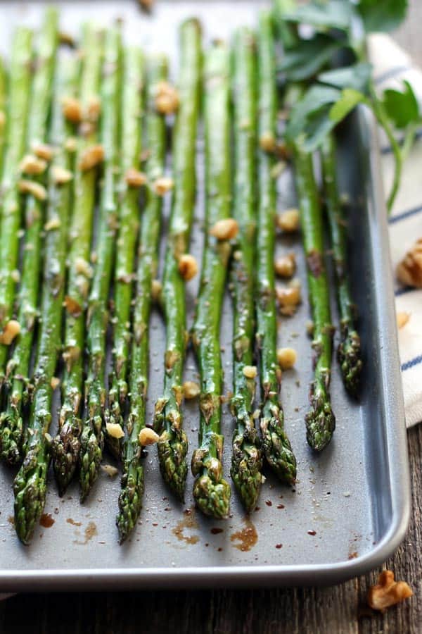 Closeup of cooked asparagus on a pan with walnuts.