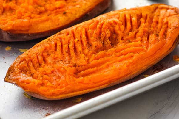 Baked sweet potato half mashed and seasoned with cinnamon.
