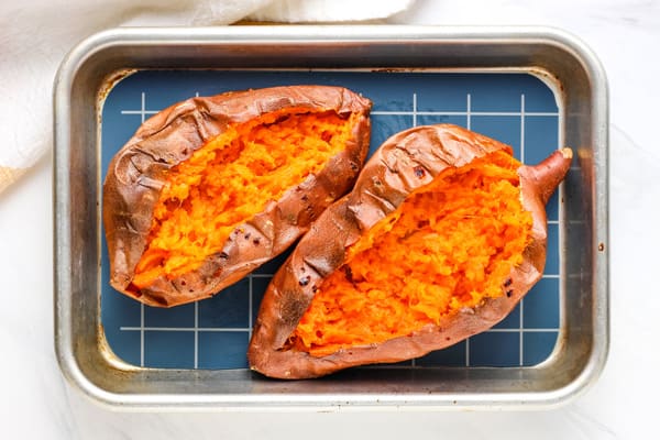 Pair of baked sweet potatoes opened and fluffed.