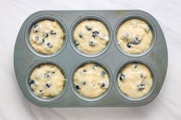 Metal muffin pan filled with batter.