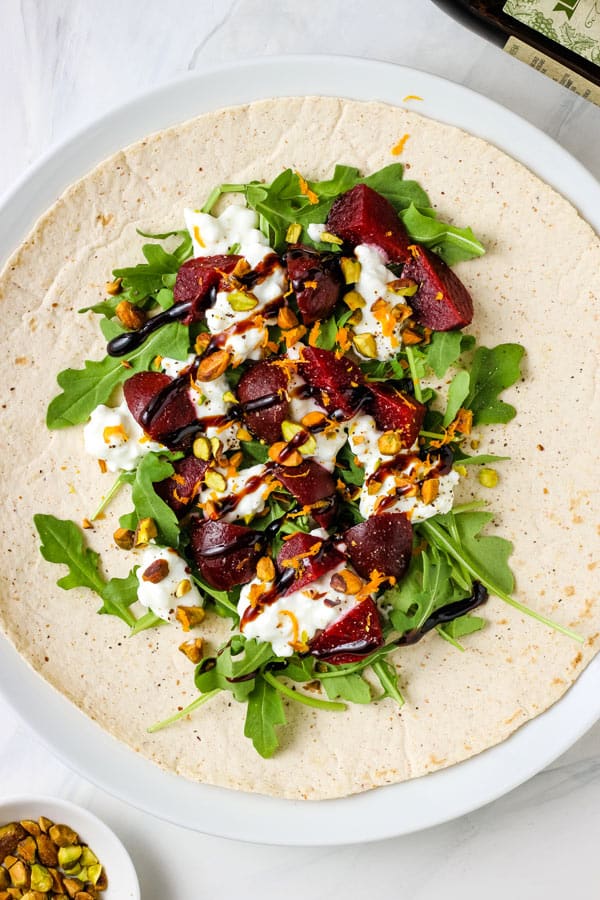 Cottage cheese, beet, and arugula wrap on a plate.